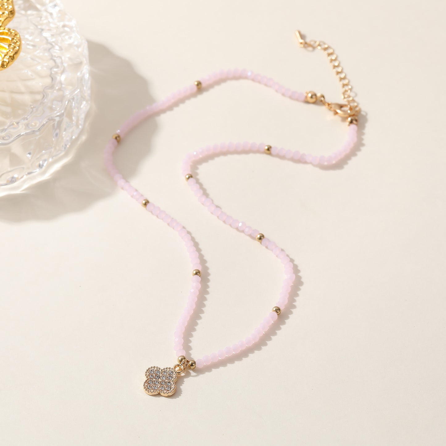 Elegant Beaded Necklace with Crystal & Gold Clover Charm - Stylish Jewelry for Women in Black, Purple, White & Pink